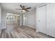 Bedroom featuring light gray walls, an updated ceiling fan, a closet with sliding doors and glass doors to the patio at 2551 Fentress Pl, Holiday, FL 34691