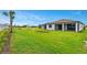 Spacious backyard with lush green grass, palm trees, and a well-manicured lawn at 2760 Winding Creek Trl, North Port, FL 34289