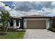 Charming single-story home with a two-car garage and paver driveway surrounded by a beautiful landscaped yard at 2760 Winding Creek Trl, North Port, FL 34289