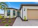 Beautiful home entrance featuring a blue front door, brick-paved walkway and manicured landscaping at 2760 Winding Creek Trl, North Port, FL 34289