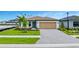 Charming single-story home with a well-manicured lawn and a brick-paved driveway leading to the garage at 2760 Winding Creek Trl, North Port, FL 34289