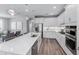 Bright kitchen with modern pendant lights, white cabinetry, and a spacious island at 2760 Winding Creek Trl, North Port, FL 34289