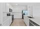 Bright kitchen showcasing stainless steel appliances, white cabinets, and a stylish tile backsplash at 2760 Winding Creek Trl, North Port, FL 34289