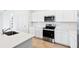Well-lit kitchen with modern stainless steel appliances, ample countertop space, and white cabinetry at 2760 Winding Creek Trl, North Port, FL 34289