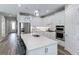 Modern white kitchen with stainless steel appliances and a large center island with seating at 2760 Winding Creek Trl, North Port, FL 34289