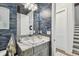 Stylish bathroom featuring a marble countertop, elegant wallpaper, and modern lighting fixtures at 3607 W Roland St, Tampa, FL 33609