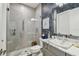 Modern bathroom with a glass shower, marble vanity, stylish lighting, and decorative wallpaper at 3607 W Roland St, Tampa, FL 33609