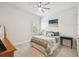Bright bedroom with ceiling fan, shuttered window, and decorative comforter with light-gray carpet at 3607 W Roland St, Tampa, FL 33609