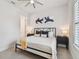 Modern bedroom with a black metal bed frame, white bedding, and shuttered windows at 3607 W Roland St, Tampa, FL 33609