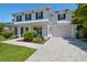 View of the home's exterior showcasing the gray roof, brick driveway, and two-car garage at 3607 W Roland St, Tampa, FL 33609