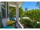 Inviting front porch with comfortable chairs, a small table, and lush landscaping at 3607 W Roland St, Tampa, FL 33609