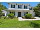 Charming two-story home with manicured front lawn, a brick walkway, and flowering bushes at 3607 W Roland St, Tampa, FL 33609
