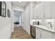 Hallway featuring a wet bar with white cabinetry, marble countertop, wine fridge and sink at 3607 W Roland St, Tampa, FL 33609