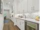 Gourmet kitchen features a marble countertop, beverage fridge, and white cabinets with modern hardware at 3607 W Roland St, Tampa, FL 33609