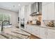 Modern kitchen boasts white cabinets, stainless steel appliances, marble countertops, and tile backsplash at 3607 W Roland St, Tampa, FL 33609
