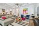 Bright living room with coffered ceilings, neutral-toned furniture, and wood floors with view of the kitchen at 3607 W Roland St, Tampa, FL 33609