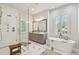 Spa-like main bathroom with a glass shower, soaking tub, marble counters and tile flooring at 3607 W Roland St, Tampa, FL 33609