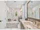 Spacious main bathroom featuring a glass-enclosed shower, dual vanities, and marble countertops at 3607 W Roland St, Tampa, FL 33609