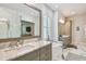 Luxurious main bathroom featuring marble countertops, dual sinks, a soaking tub, and a glass-enclosed shower at 3607 W Roland St, Tampa, FL 33609