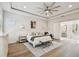 Bright and airy main bedroom with a large bed, ensuite bathroom, and decorative ceiling fan at 3607 W Roland St, Tampa, FL 33609