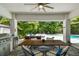 Covered patio featuring dining area and outdoor kitchen with view of pool at 3607 W Roland St, Tampa, FL 33609