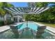 The backyard boasts a sparkling pool with lounge chairs, lush landscaping, and an umbrella at 3607 W Roland St, Tampa, FL 33609