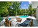 Relaxing backyard with a pool, spa, and comfortable seating area with a fire pit at 3607 W Roland St, Tampa, FL 33609