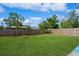 A large, manicured backyard with a wooden fence and lush green grass at 413 Blackburn Rd, Nokomis, FL 34275