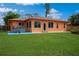 Spacious backyard featuring a hot tub, green lawn, and the exterior of the home at 413 Blackburn Rd, Nokomis, FL 34275
