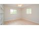 A bright bedroom featuring two windows, neutral walls, and light hardwood flooring at 413 Blackburn Rd, Nokomis, FL 34275