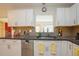 Modern kitchen with granite countertops, stainless steel dishwasher, and view to another room at 413 Blackburn Rd, Nokomis, FL 34275