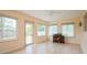 Bright sunroom with multiple windows and door to backyard, light wood flooring, and ceiling fan at 413 Blackburn Rd, Nokomis, FL 34275