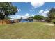Spacious, fenced backyard featuring a large green lawn and shade trees, perfect for outdoor activities at 4507 26Th S Ave, Tampa, FL 33619