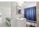 Clean bathroom with a white vanity, updated fixtures, and a shower with a stylish blue curtain at 4902 Blue Heron Dr, New Port Richey, FL 34652