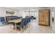 Bright dining room features a wooden table with blue chairs, white tile floors, and view to the living room at 4902 Blue Heron Dr, New Port Richey, FL 34652
