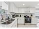 Modern white kitchen features stainless steel appliances and granite countertops at 4902 Blue Heron Dr, New Port Richey, FL 34652