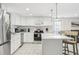 Modern white kitchen features stainless steel appliances, kitchen island, and granite countertops at 4902 Blue Heron Dr, New Port Richey, FL 34652