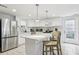 Modern white kitchen features stainless steel appliances, kitchen island, and granite countertops at 4902 Blue Heron Dr, New Port Richey, FL 34652