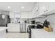 Modern white kitchen features stainless steel appliances and granite countertops at 4902 Blue Heron Dr, New Port Richey, FL 34652