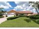 Well-maintained single-Gathering home featuring a manicured lawn, attached garage, and lush landscaping at 4973 60Th S Ave, St Petersburg, FL 33715