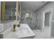 Elegant bathroom with marble walls, dual sink vanity, and glass-enclosed shower with gold fixtures at 5180 69Th N Ave, Pinellas Park, FL 33781