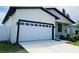 Beautifully designed home featuring a two-car garage, modern lighting fixtures, and a lush green lawn at 5180 69Th N Ave, Pinellas Park, FL 33781