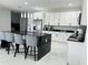 Modern kitchen with a black marble island, barstool seating, and stainless steel appliances at 5180 69Th N Ave, Pinellas Park, FL 33781