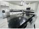 Modern kitchen featuring white cabinets, black countertops, stainless steel appliances, and a spacious island at 5180 69Th N Ave, Pinellas Park, FL 33781