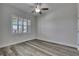 A clean bedroom with a window with shutters and wood-look flooring at 5814 Stockport St, Riverview, FL 33578