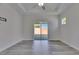 Bright bedroom featuring tray ceiling, ceiling fan, sliding glass door to the lanai, and stylish gray wood-look floors at 5814 Stockport St, Riverview, FL 33578
