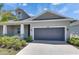 Charming home featuring a gray exterior, two-car garage, landscaped yard, and covered front porch at 5814 Stockport St, Riverview, FL 33578
