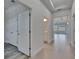 Bright hallway view towards an open living space with wood-look tile flooring and neutral paint at 5814 Stockport St, Riverview, FL 33578