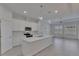 Well-lit kitchen with white cabinets, stainless steel appliances, and a center island overlooking the living area at 5814 Stockport St, Riverview, FL 33578