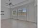 Bright living room with tile floor, ceiling fan, large windows with shutters, and sliding glass doors at 5814 Stockport St, Riverview, FL 33578